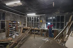 Central Europe Atmosphere Drucke: Young man working in his workshop in the evening