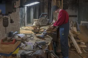 Young Man In Workshop Drucke: Young man working in his workshop in the evening