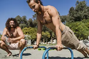 Portugal Beach Scene Drucke: Two young men exercising on the bars during beach training