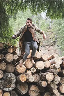 Forest Landscape Photography Drucke: Young men on logs in the forest