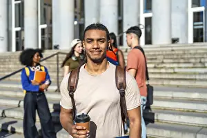 Educational Institution Photos Drucke: Young multiracial student drinking coffee