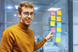 Young Engineer Drucke: Young smiling engineer pointing to an idea written in an adhesive note