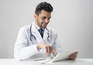 Medical Diagnosis Drucke: Young smiling internist using tablet computer