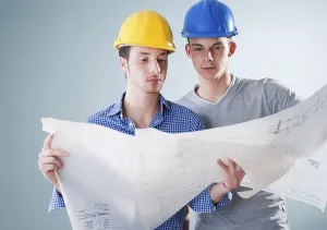 Construction Work Drucke: Two young tradesmen looking at a building plan