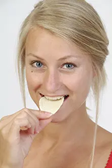 Salty Snack Photography Drucke: Young woman eats chips