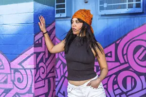 Zeitgenössische Kunst Drucke: Junge Frau lehnt sich an eine lebendige blaue und rosa Graffitifassade.