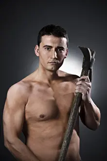 Dark Background Studio Shot Drucke: Young worker with pickaxe over black background